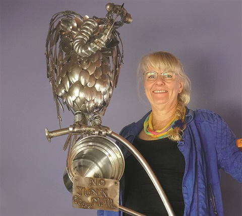 Lily Podgers with her sculpture made of spoons