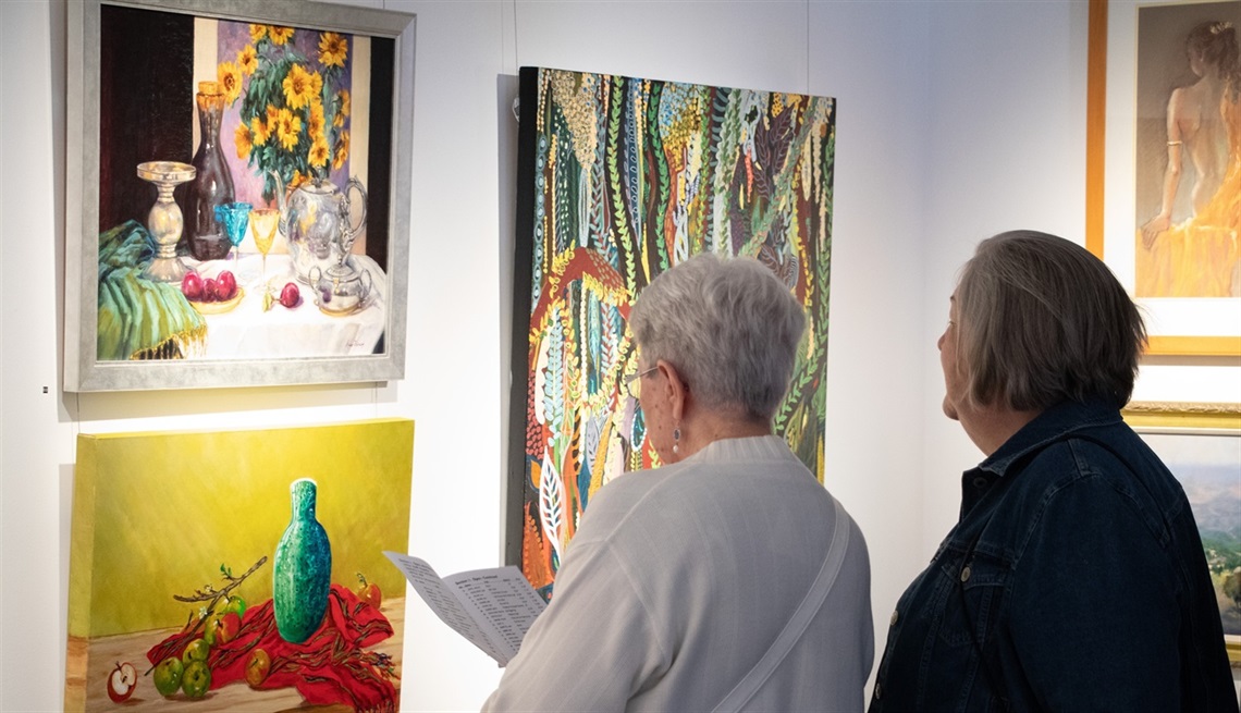 Visitors admiring artwork at the 2025 Hervey Bay Art Society exhibition opening