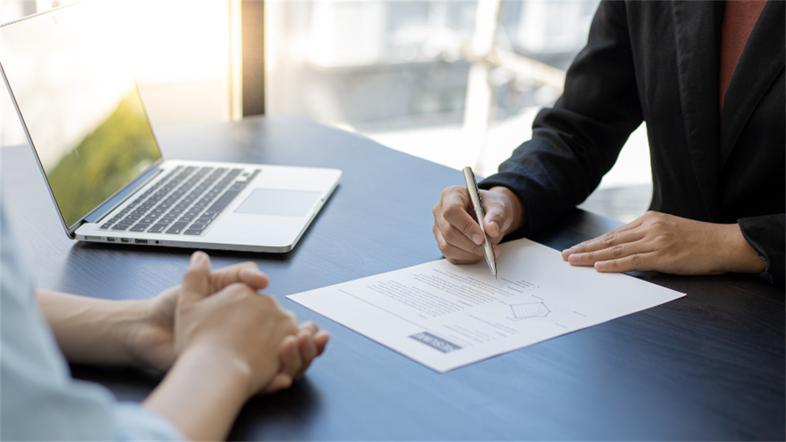 People filling out paperwork on table