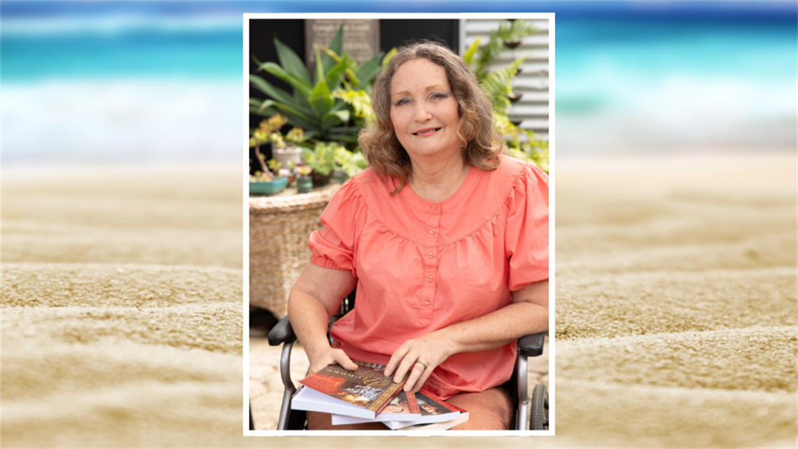 Image of Karen sitting in a wheelchair with books on her lap