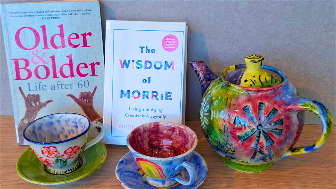 A colourful tea pot and teacups with books