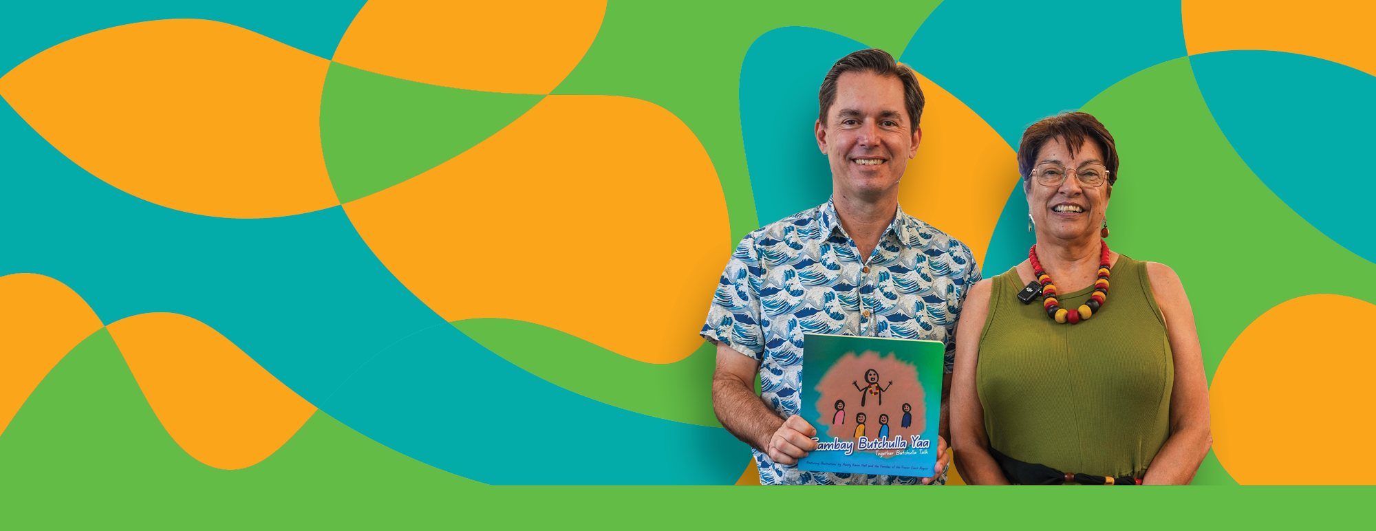 Aunty Karen Hall with Mayor George Seymour holding a copy of Gambay Butchulla Yaa