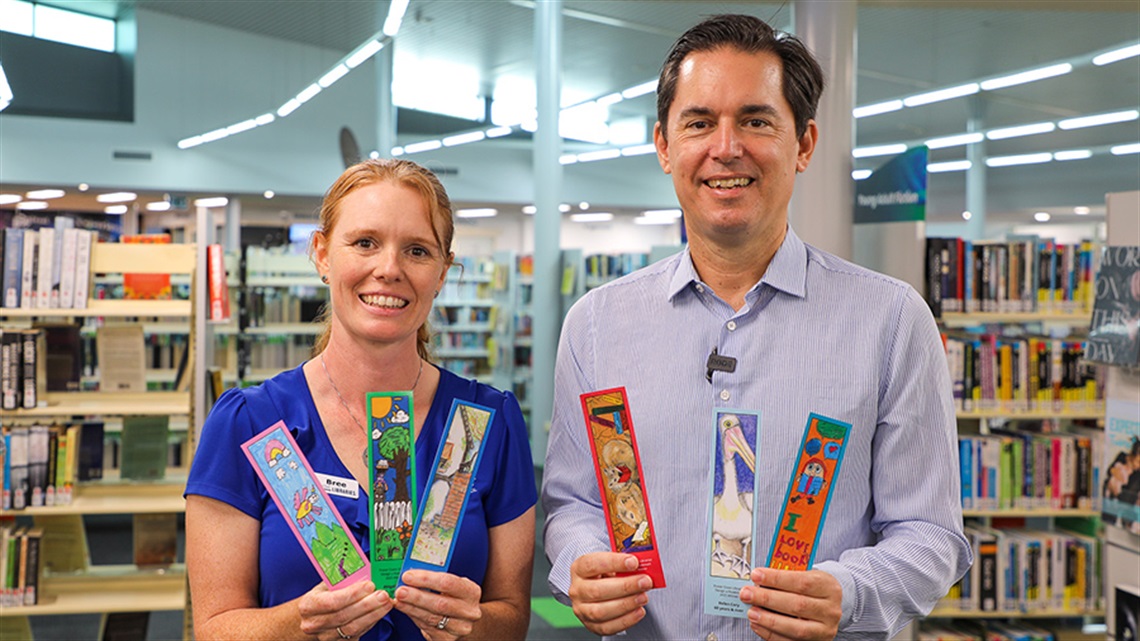 Mayor George Seymour with Fraser Coast Libraries Librarian holding bookmarks